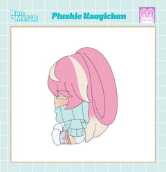 A chibi-style plushie illustration of Usagichan with pink hair, a light blue outfit, and white accents, centered on a white card with a pale blue grid border. Text at the top reads 'Plushie Usagichan' with 'Ran Merch' branding in the corner.